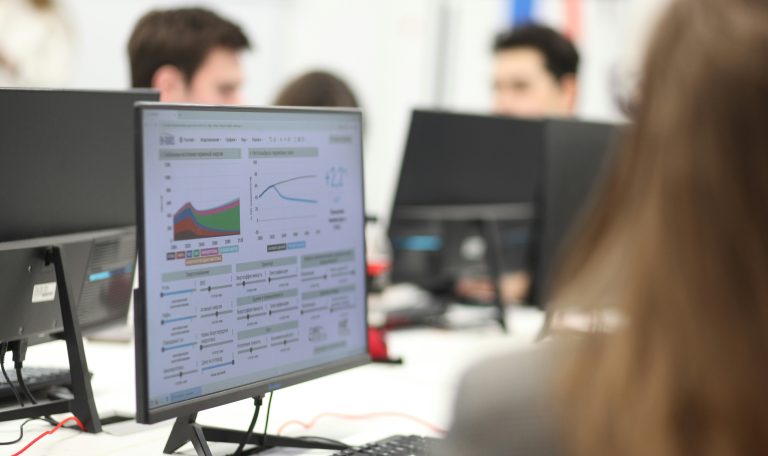Estadisticas en una empresa estadisticas en una computadora y varias alrededor con personal coordinando